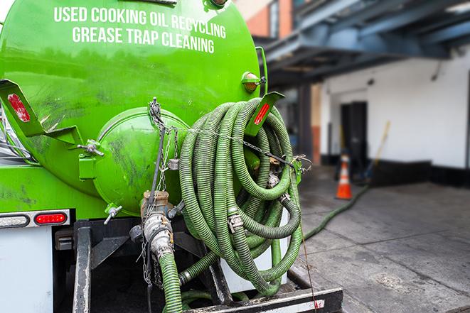 a technician pumping a grease trap in a commercial building in Gulf Stream, FL